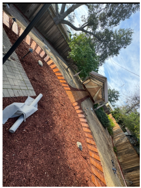 Renovated backyard with fresh mulch and brick edging